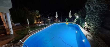 Una piscina iluminada de noche.