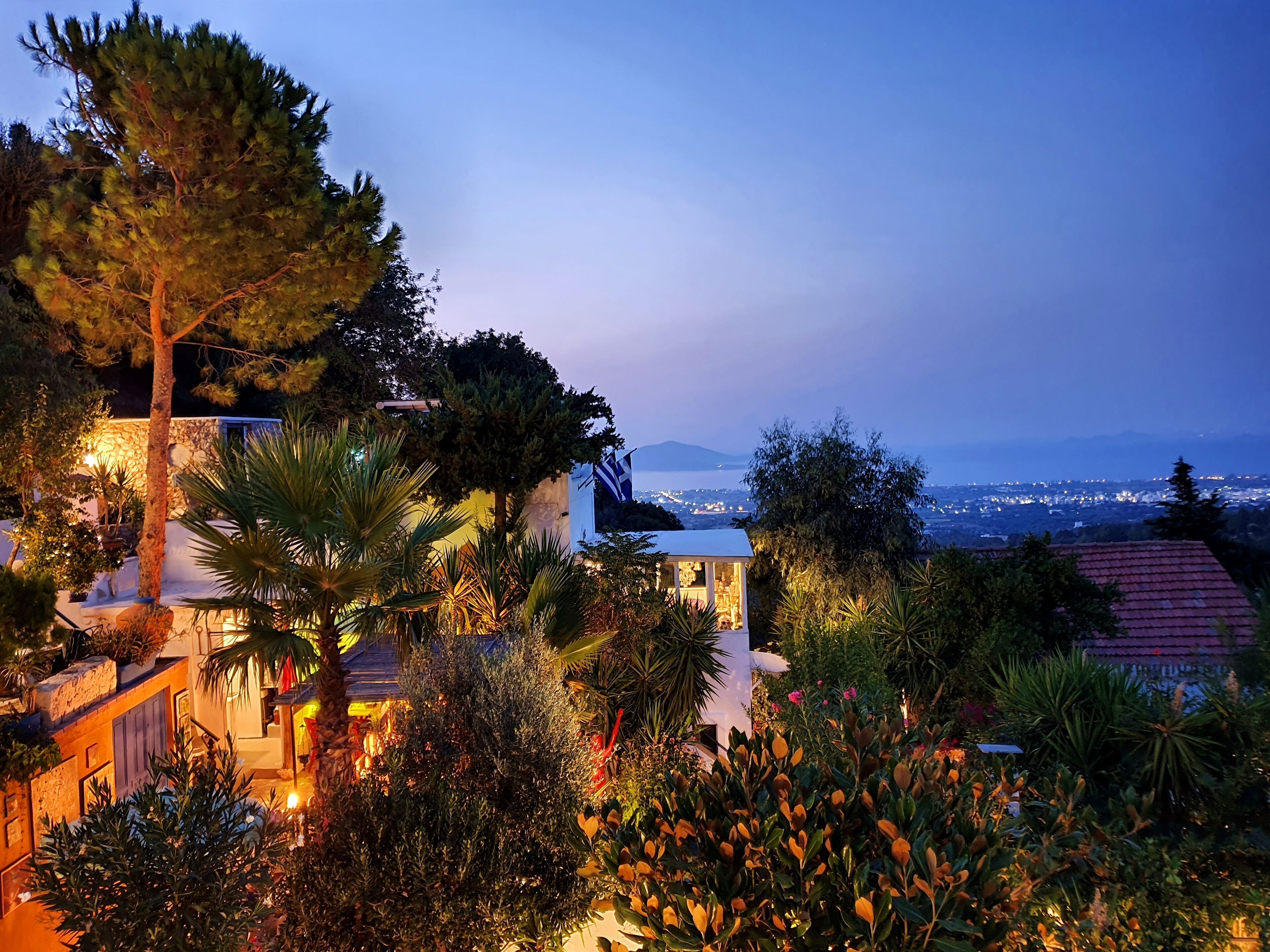 A well-lit residential area with a view of a cityscape and mountains in the distance.
