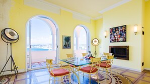 A dining area with a glass table, red cushioned chairs, a patterned floor, and a painting on the wall. - LE CAP DE NICE VI4150 by RIVIERA HOLIDAY HOMES (Niza)
