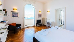A hotel room with a bed, a desk, a chair, a bookshelf, and a view of the outdoors. - LE CAP DE NICE VI4150 by RIVIERA HOLIDAY HOMES (Niza)