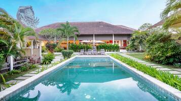 Una piscina al aire libre, tumbonas