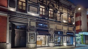Et hotel med en klassisk facade, med et tydeligt skilt for 'Monarca Hotel & Culture'.