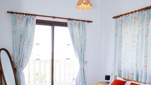 A bedroom with a bed, a bedside table, a mirror, and a view of the outside balcony. - Stunning 4 Bedroom Villa -Private Pool - Sea View (Peyia)