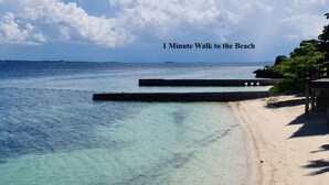 A beach with clear turquoise water and a wooden pier. - Lux. 2BR condo + 2 pools, woow oceanviews, Gym, Beach,near Mactan Newtown, Tours (Lapu-Lapu City)