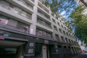 A multi-story building with balconies, large windows, and a storefront at the ground level. - Feng Chia Love Heart (Taichung)