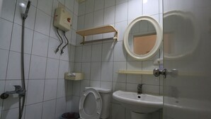 A bathroom with a toilet, sink, shower, and a mirror. - Feng Chia Love Heart (Taichung)