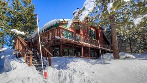 A wooden cabin with a balcony, surrounded by snow-covered trees. - Tahoe Olympic Condo | Carson Valley Views (Stateline)