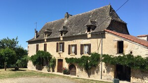 Un bâtiment traditionnel en pierre, doté de nombreuses fenêtres et d’un toit recouvert de tuiles.