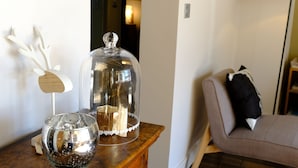 A wooden cabinet with a glass dome and a decorative bowl on top.