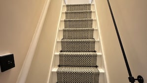 Eine Treppe mit gemustertem Teppich und einer Handläufe.