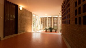 A hallway with a wooden door, glass doors, and a brick wall with a lattice design. - The. Loft. by. Guido (Vicenza)