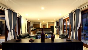 A modern living room with a dark wooden coffee table, two vases, and a leather sofa. - Villa Luna (Kuta)