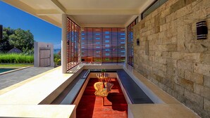 A modern outdoor area with a pool, a red carpet, and a decorative table. - Villa Luna (Kuta)