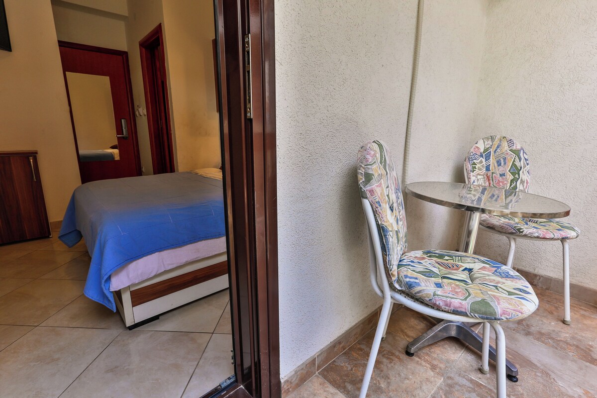 A room with a bed, a chair, and a small table.