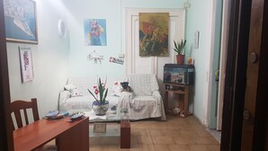 A living room with a sofa, a coffee table, a bookshelf, and a door. - B&B Miraglia (Naples)