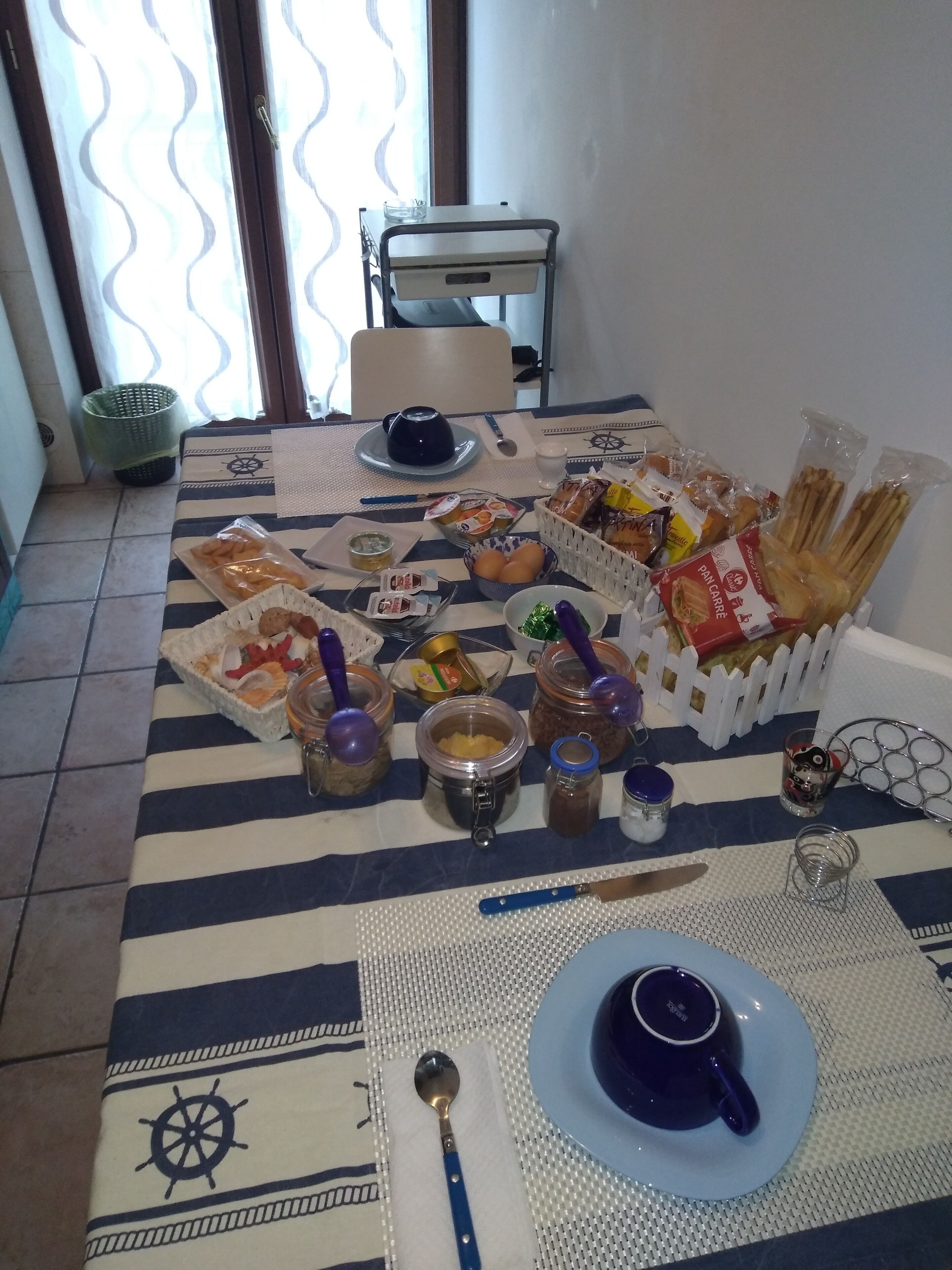 A dining table set with various food items, utensils, and a decorative mat.