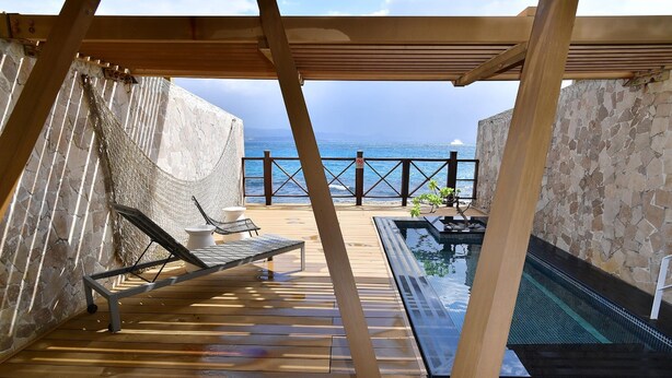 A wooden deck with a pool, lounge chairs, and a view of the ocean. - Volando Kenting (Hengchun)