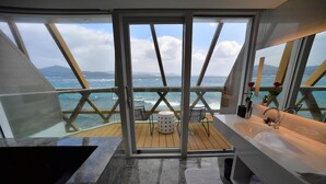 A modern bathroom with a large window, a bathtub, and a sink. - Volando Kenting (Hengchun)