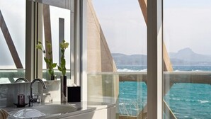 A modern bathroom with a large mirror, a sink, and a view of the ocean. - Volando Kenting (Hengchun)