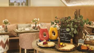 Un comedor acogedor con paneles de madera, una mesa de madera con diversos platos y un menú en una pizarra.