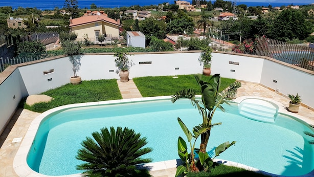 A swimming pool with a view of the sea and surrounding houses. - Villa with private pool, sicily, Palermo. (Trabia)