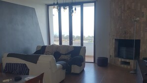 A modern living room with a sofa, a dining table, and a fireplace. - Villa with private pool, sicily, Palermo. (Trabia)