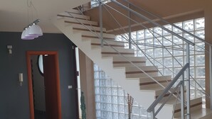 A modern staircase with a metal railing, leading to an upper floor. There are potted plants and decorative spheres on the lower landing. - Villa with private pool, sicily, Palermo. (Trabia)