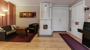 A living room with a fireplace, a sofa, a coffee table, and a television. - Hagbackens GĂ„rd Bed & Breakfast (Ărebro)