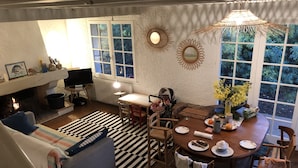 Een gezellige woonkamer met een open haard, een eettafel en een comfortabele bank.