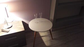 A round table with two clear glasses on it, a lamp, and a wooden floor. - Campo Sportivo (Taurianova)