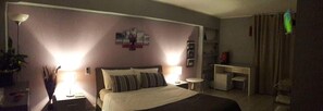 A hotel room with a bed, bedside tables, a desk, and a chair. - Campo Sportivo (Taurianova)