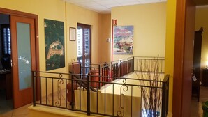 A hallway with a staircase, a door, and a poster on the wall. - Masseria Frangiosa (Torrecuso)