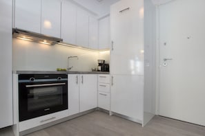 Apartamento, 2 quartos | Cozinha privada | Geladeira grande, fogão, cooktop, cafeteira/chaleira