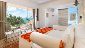 Ein Hotelzimmer mit Balkon, einem Bett, einer Sitzecke und Meerblick.