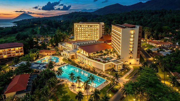 A resort with multiple buildings, a swimming pool, and a view of a mountain. - NDC Resort (Manado)