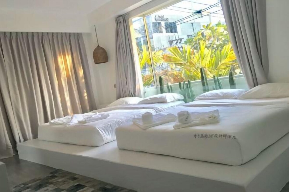 Habitación de hotel con una cama grande, vistas al exterior y un diseño moderno.