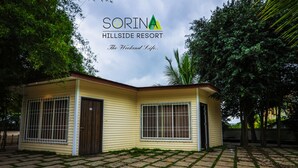 A small, single-story building with a yellow exterior, large windows, and a door. - Sorina Hillside Resort (Pune)