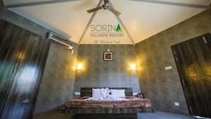 A hotel room with a bed, a ceiling fan, and a sign reading "SORINA HILLSIDE RESORT". - Sorina Hillside Resort (Pune)