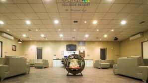 A hotel lobby with a reception desk, seating area, and a decorative elephant sculpture. - Sorina Hillside Resort (Pune)