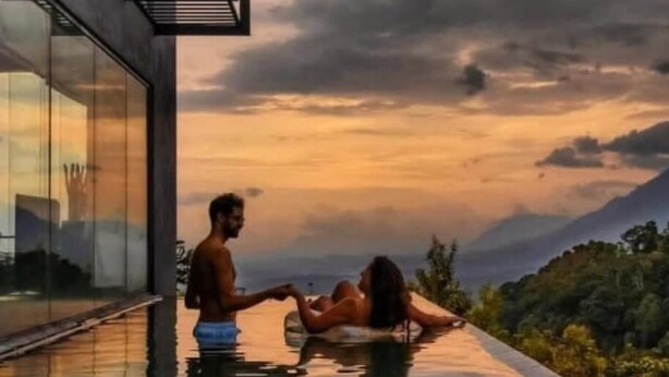 A couple relaxing in a modern infinity pool with a scenic mountain view. - Romance Valley (Hildummulla)