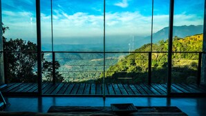 A room with a large window offering a view of a mountainous landscape. - Romance Valley (Hildummulla)