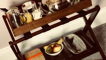 A wooden serving tray with various kitchen items and fruits.