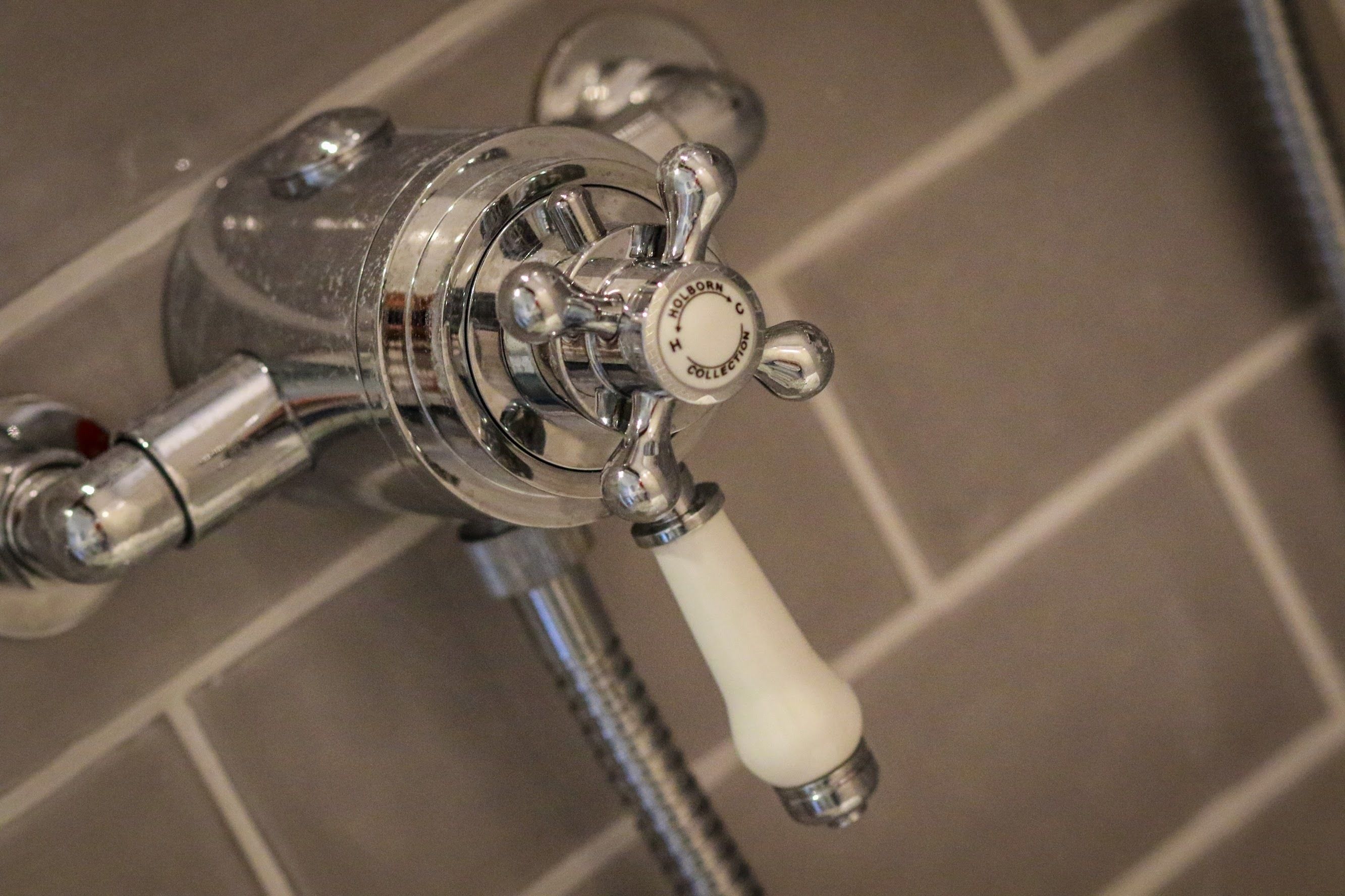 A bathroom faucet with a white handle and a label that reads "Holborn Collection."