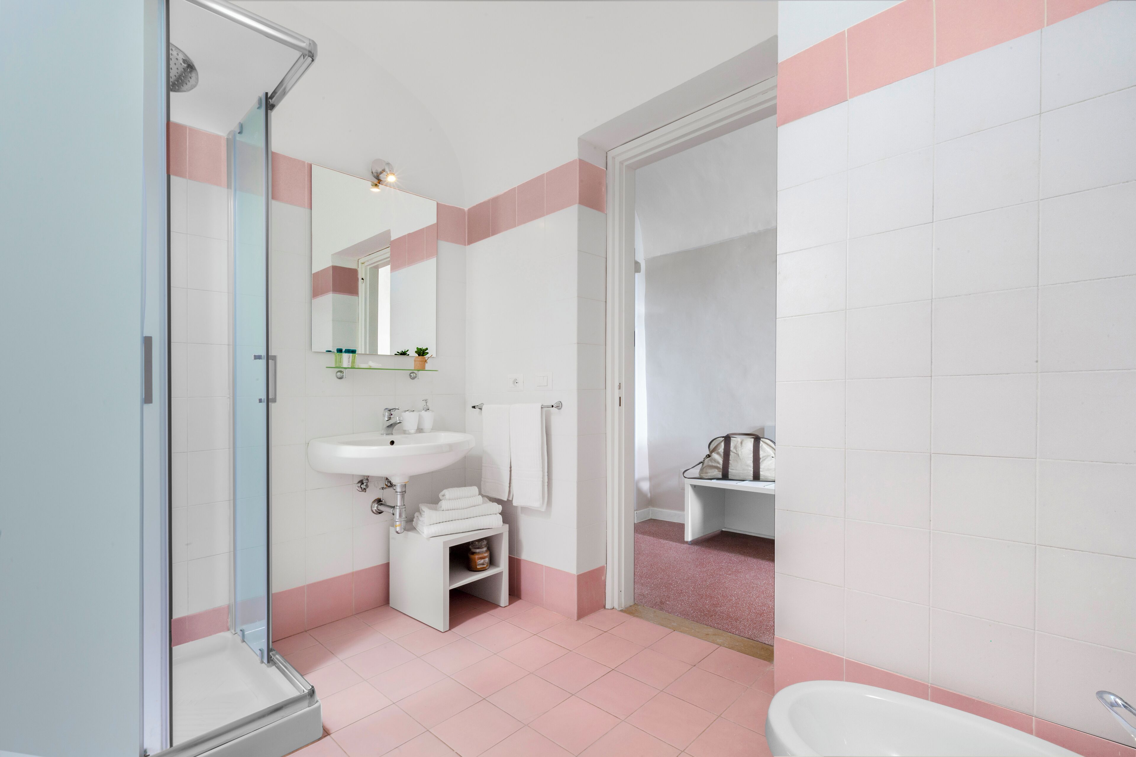 A bathroom with a glass-enclosed shower, a sink, and a bathtub.