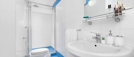 A modern bathroom with a shower, toilet, bidet, and sink.