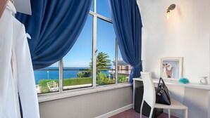 A room with a large window, a white chair, a small table, and a mirror. - Porto Salvo (Sant'Agnello)