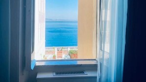 A window with a view of the sea and a building across the water. - Porto Salvo (Sant'Agnello)