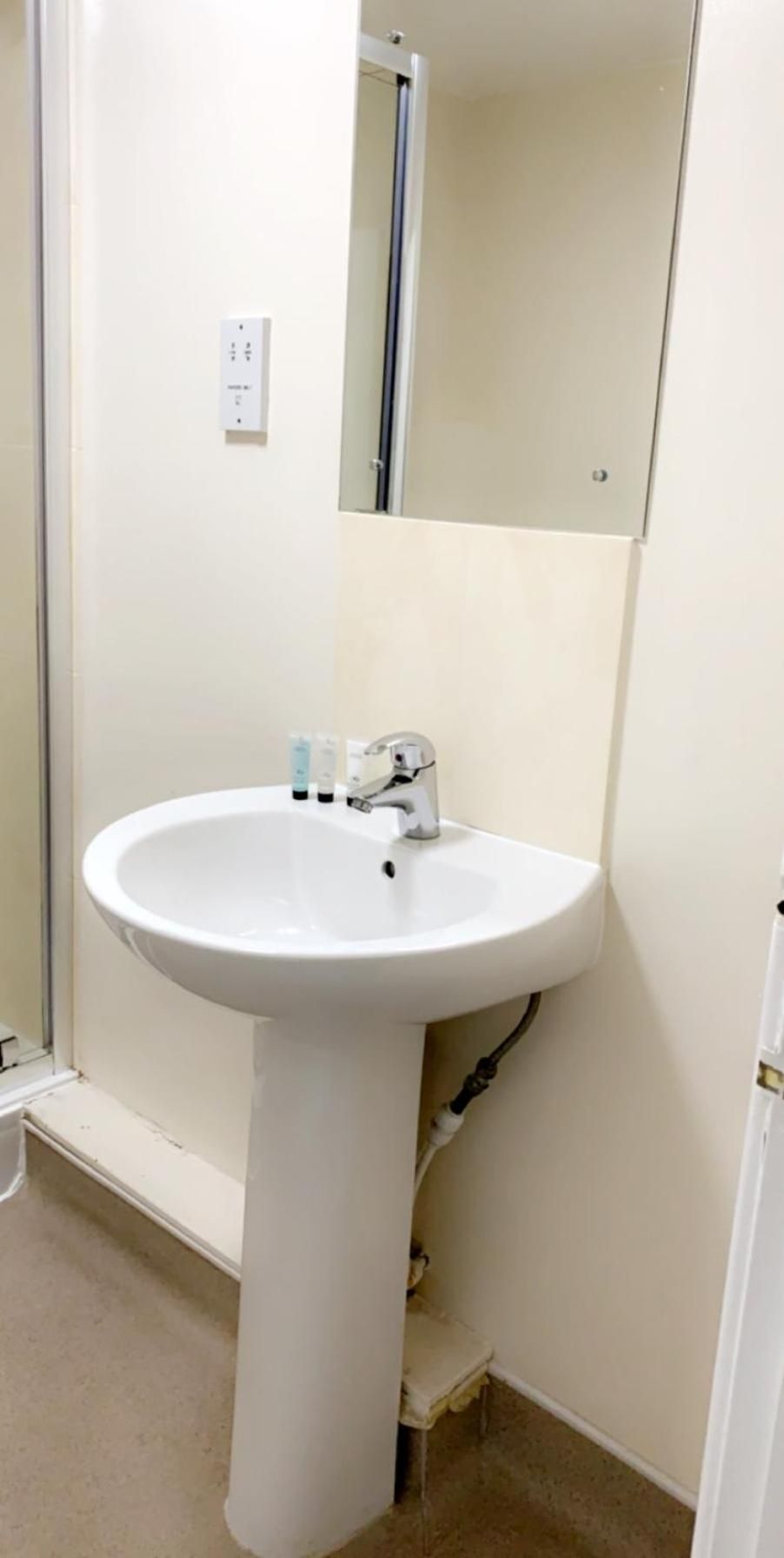 A bathroom with a white sink, a mirror, and a towel rack.