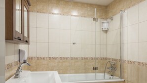 A bathroom with a sink, mirror, bathtub, shower, and toilet. - Penmoor Chance - Old Town (Bratislava)