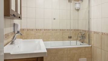 Superior appartement, meerdere bedden, uitzicht op tuin | Badkamer | Een bad, een haardroger, pantoffels, handdoeken